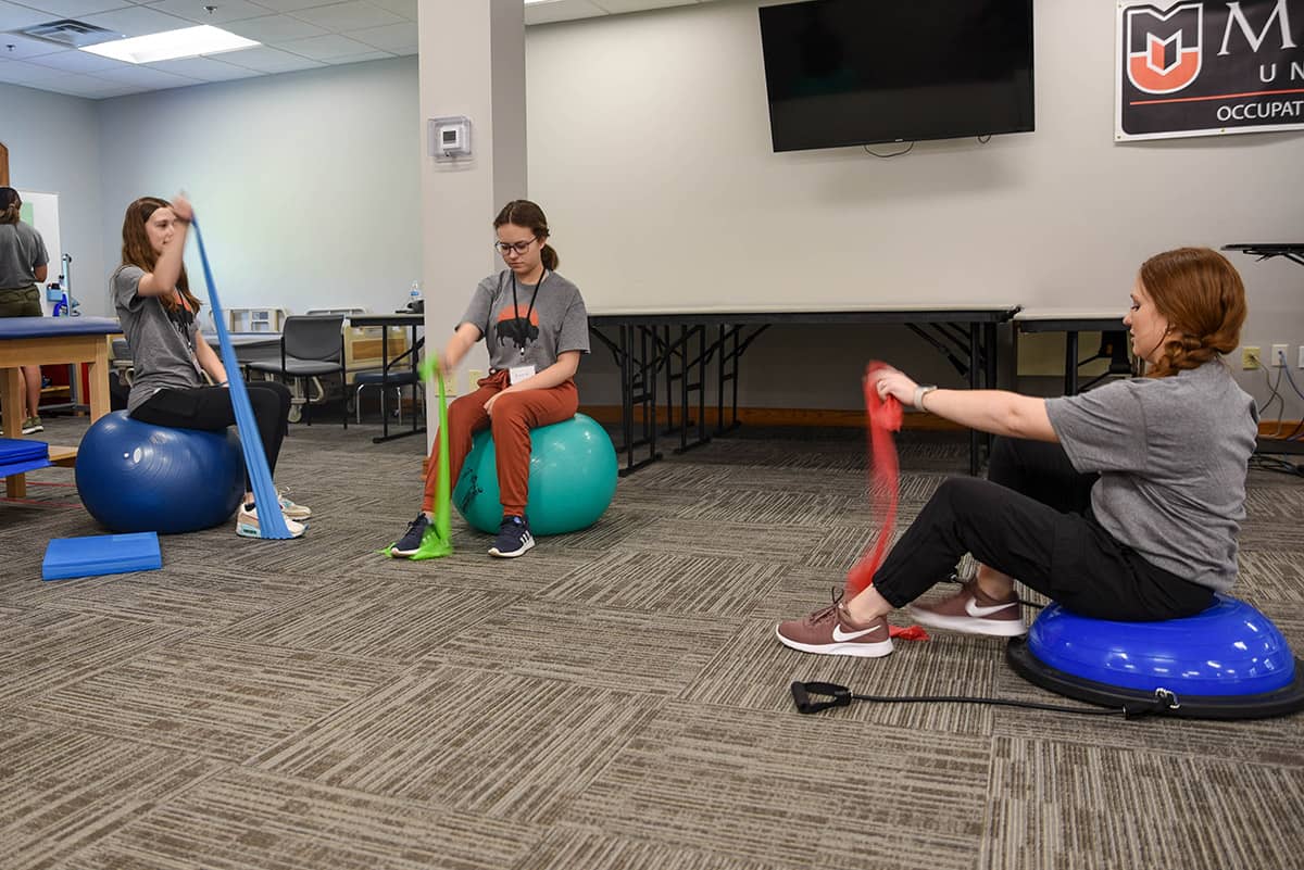 kids learn how to stretch with bands during occupational therapy camp